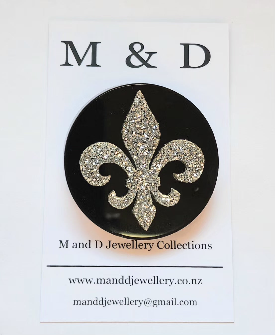 Brooch Black Disc with Silver Glitter Fleur de lis layer.